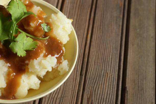 istock Bowl of Mashed Potatoes and Gravy against Rustic Wood Background 978575598