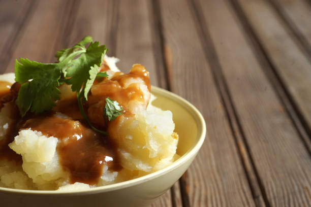 istock Bowl of Mashed Potatoes and Gravy against Rustic Wood Background 978575602
