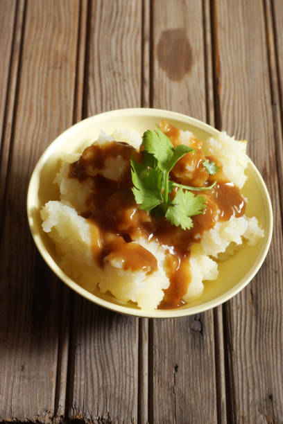 istock Bowl of Mashed Potatoes and Gravy against Rustic Wood Background 978575626