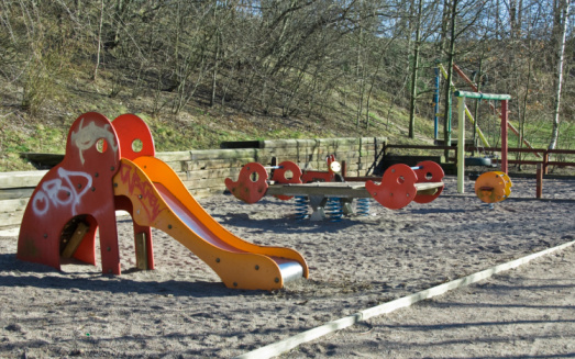 Empty playground with toys covered in graffiti