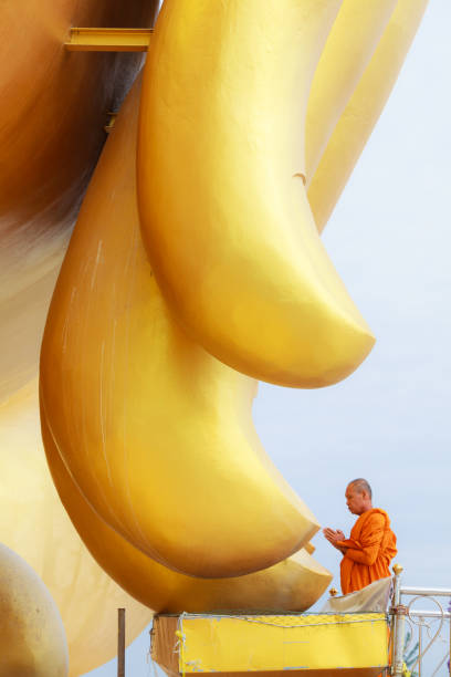монах, молясь за пальцы большого золотого будды в ват муанг (буддийский храм муанг), анг тхонг, таиланд - praying figurine people men стоковые фото и изображения