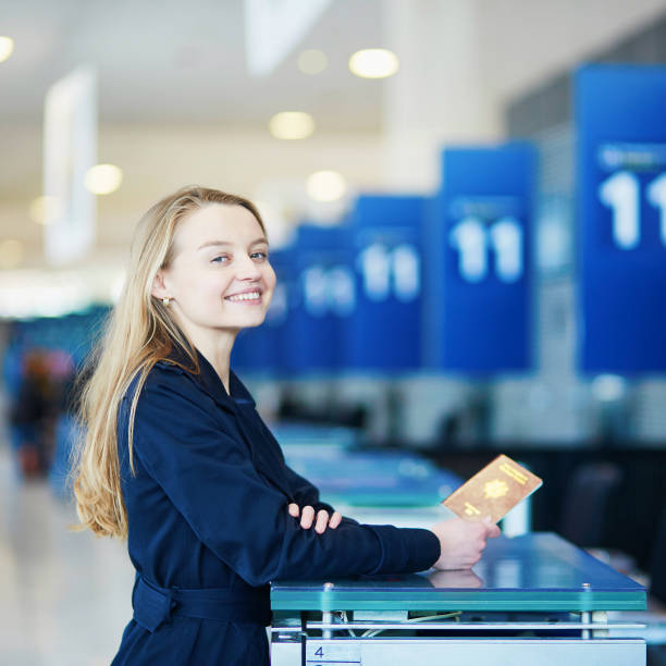женщина в международном аэропорту на регистрации счетчик, давая ей паспорт - airport airport check in counter ticket ticket machine стоковые фото и изображения