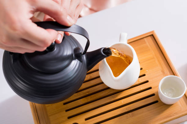 istock partial view of woman pouring tea into jug while having tea ceremony at home 978609470
