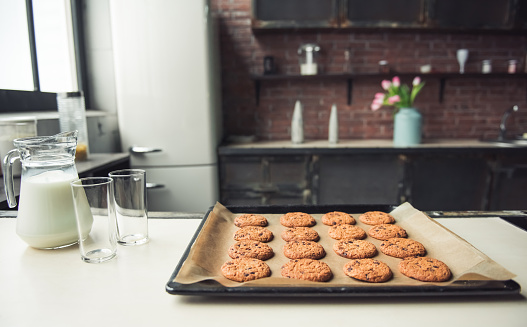 Tasty homemade cookies lying on sheet pan on the kitchen table
