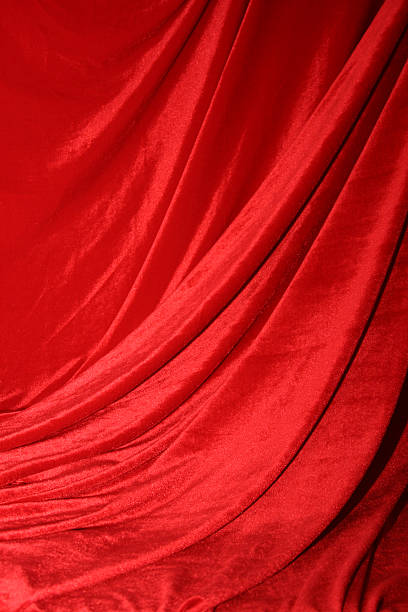 A dramatic red curtain like at a play lit for effect red velvet material stock pictures, royalty-free photos & images