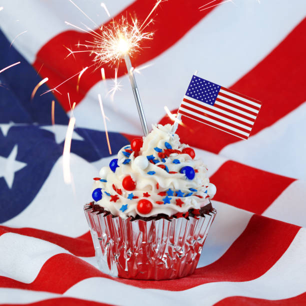 istock 4th of July cupcake with flag, sprinkles, and sparkler 978657862