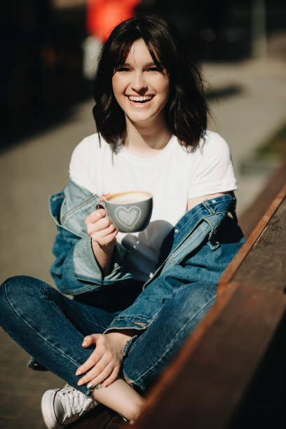 istock Happy woman sitting with coffee on bench 978674868