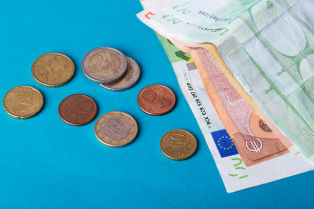 istock euro banknotes of different value and coins on a blue background 978702748