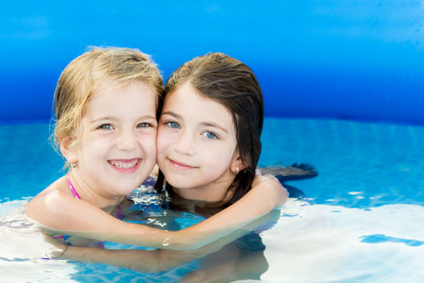 istock Little cute girls in pool with copy space 978721942