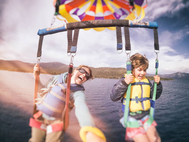 mutter und 9 jahre alten sohn parasailing über schönen lake tahoe, kalifornien im frühsommer - 9 year old stock-fotos und bilder