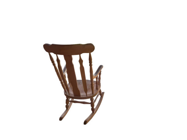 rocking chair in the corner of a room with old hardwood flooring. front view