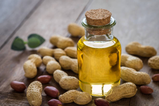 istock Peanut oil in glass bottle and peanuts on wooden table 978736986