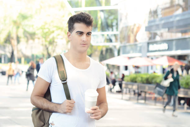 istock Young attractive man holding coffee in sunny park 978746680