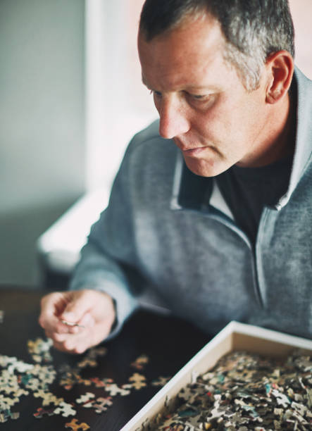 istock Mature man at home working on jigsaw puzzle 978776208