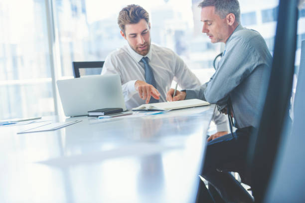istock Two businessmen meeting with technology. One man has a laptop computer. 978794170