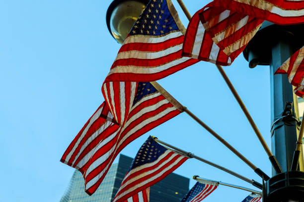 A shot of US Flags at Memorial with blue sky, clouds,