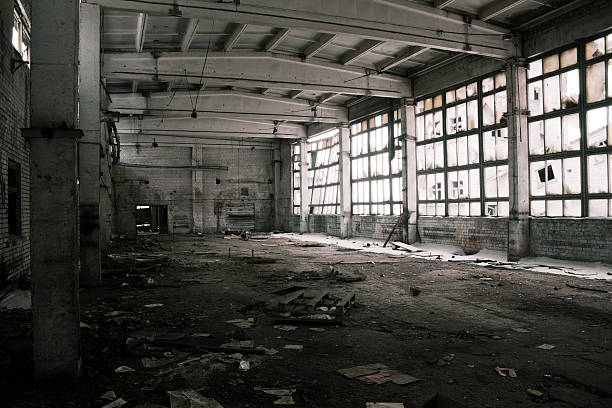 Abandoned industrial warehouse interior, black and white stock photo