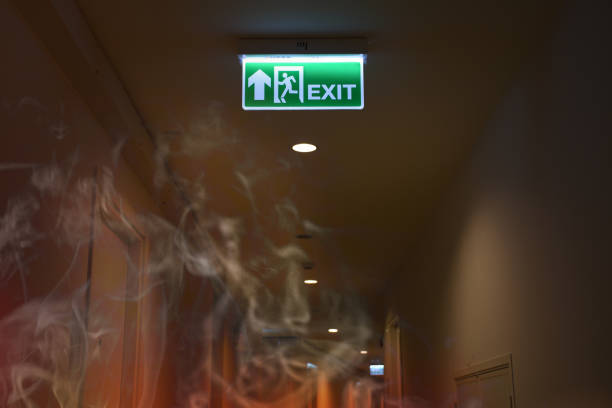 señal de salida de emergencia de fuego muestra la manera de escapar con la quemadura del fuego humo. - fire escape fotografías e imágenes de stock