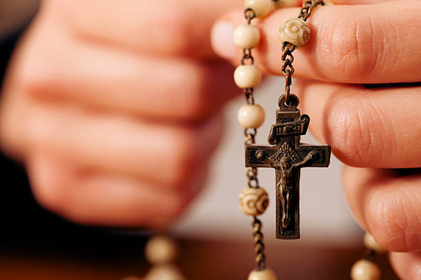 frau beten mit einem rosenkranz gott - prayer beads stock-fotos und bilder