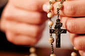 Woman praying with rosary to God