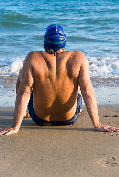 istock Male swimmer sitting on beach. 97892445