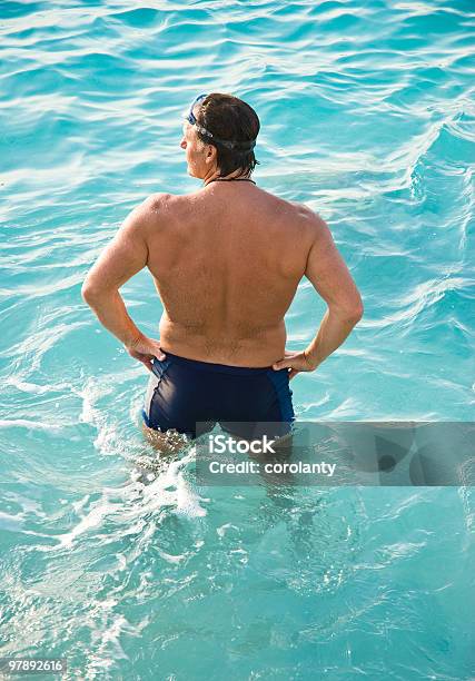 Man Standing In Turquoise Water Stock Photo - Download Image Now - Swimming Trunks, Adult, Adults Only