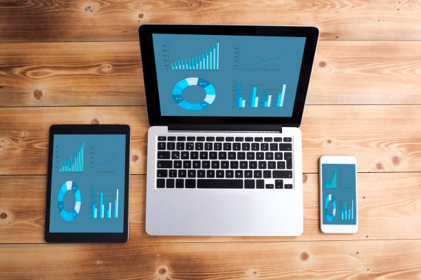 istock Smartphone, tablet pc and a laptop with infographic screen on wooden desk 978952162