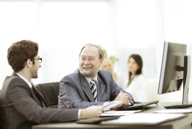 istock two businessmen discussing work issues sitting at their Desk 978969142