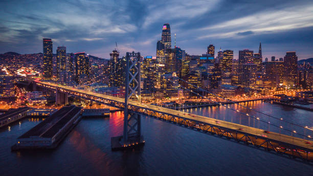 luftaufnahme der stadtbild von san francisco und die bay bridge bei nacht - bay bridge bridge california dawn stock-fotos und bilder