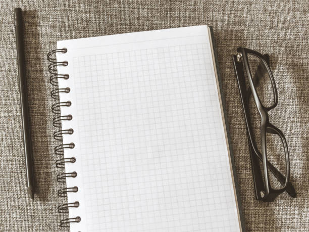 istock Top view goals list with notebook, pencil, glasses on grey fabric. Flat lay, copy space 978985962