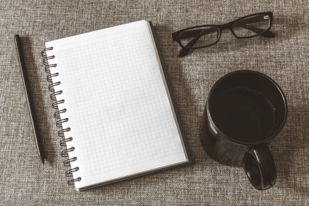 istock Top view goals list with notebook, cup of coffee on grey fabric. Flat lay, copy space 978986004