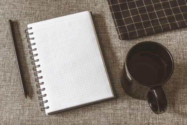 istock Top view goals list with notebook, cup of coffee on grey fabric. Flat lay, copy space 978986016