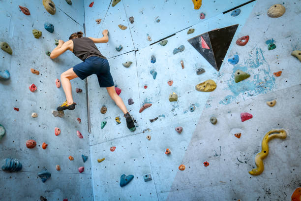 adolescente formação escalada na parede de escalada indoor - climbing wall rock climbing holding reaching - fotografias e filmes do acervo