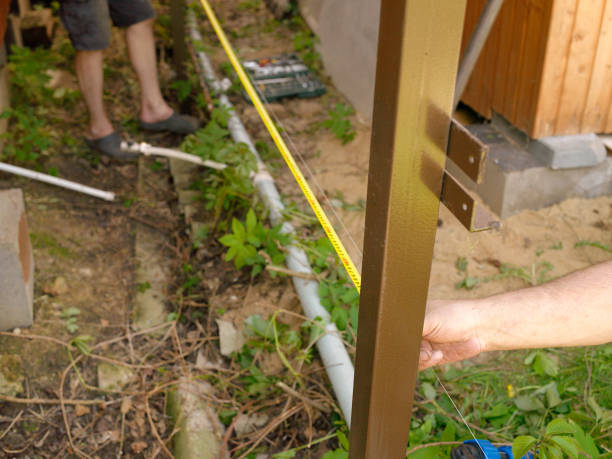 worker with measure tape Closeup up of a worker hand with measure tape above a water pipe in the backyard yard measurement stock pictures, royalty-free photos & images