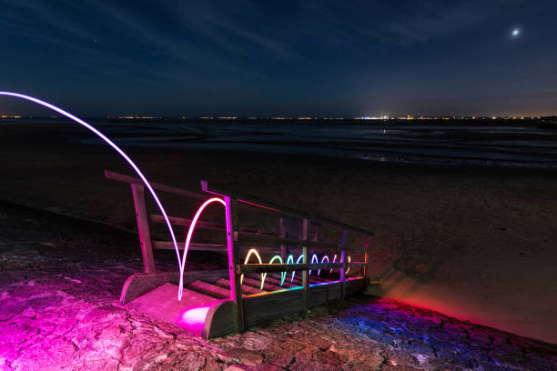 Illuminated stairs to the sea by night.