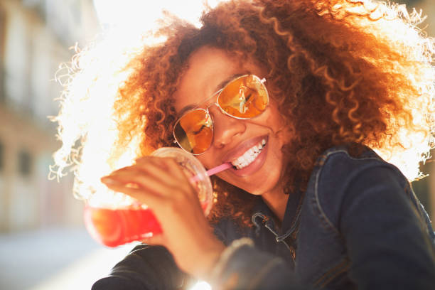 bella giovane donna con afro, ora legale. - smoothie drinking women drink foto e immagini stock