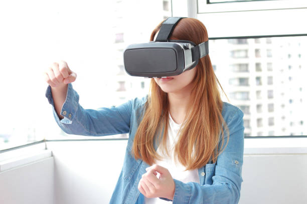 istock Young woman wearing virtual reality glasses at home. 979003376
