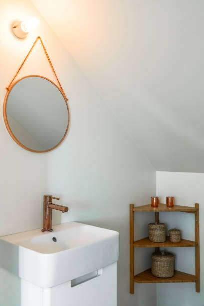 istock Basin in modern small toilet room with copper details and a round mirror 979006534