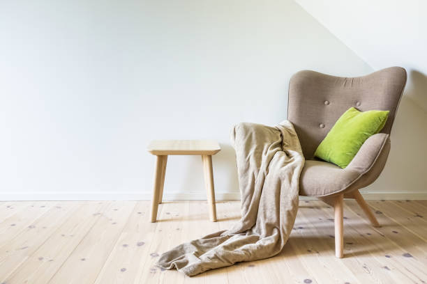 istock Beige armchair with a green pillow and blanket 979008992
