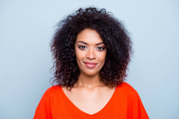 portrait de femme mignonne magnifique avec une coiffure moderne en tenue orange isolé sur fond gris. concept de soci�été de l’humanité autorité - sourire narquois photos et images de collection