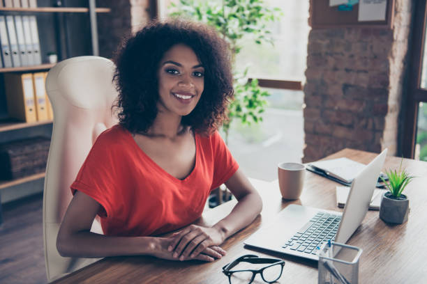 retrato de moda abogado encantador con una sonrisa radiante en traje casual, sentado en el escritorio en la oficina mirando a cámara. concepto de vector de personas persona profesión - adminstrator fotografías e imágenes de stock