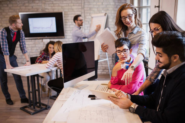 istock Group of young perspective designers discussing in office 979009736