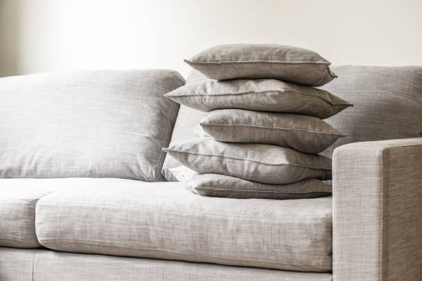 istock Pillows stacked in a pile on a big gray sofa 979012900