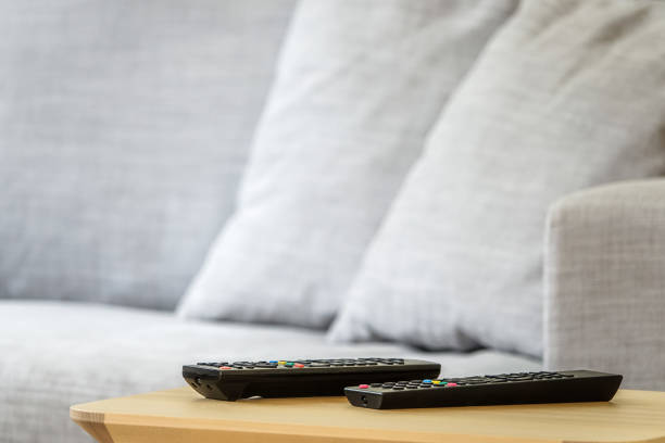 istock Interior of sunny TV room with remote controls set on a wooden table 979013220