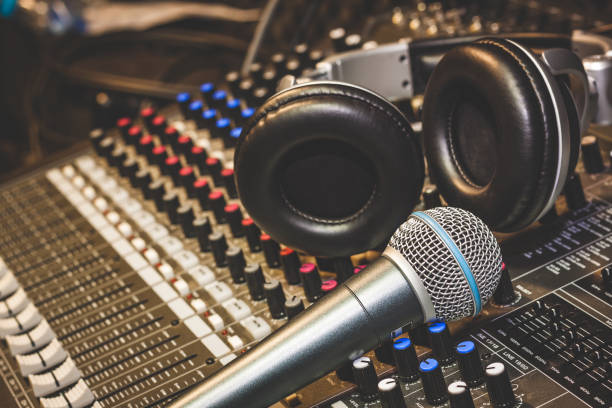 Close up instruments music background concept.Single microphone with headphones on sound mixer board in home recording studio.Free space for creative design text & wording mock up template. concepto de fondo de la música de los instrumentos de cerca. solo micrófono con auriculares en tablero de mezclador de sonido en estudio de grabación casero. espacio libre para texto de diseño creativo e imitan para arriba de la plantilla de redacción