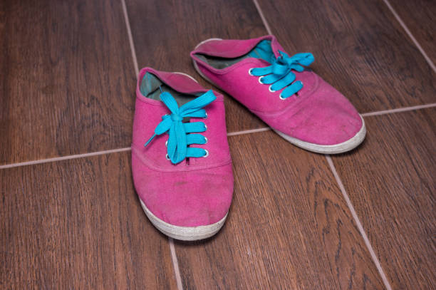 istock Old dirty fabric moccasins lying on tiled floor 979020924