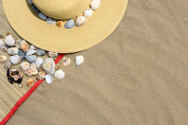 istock Beach hat on the sand, seashells. The texture of the sand. Top view, copy space. 979021816