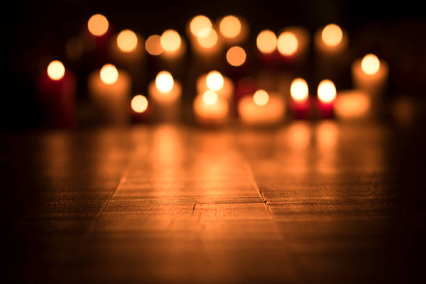 Defocused lit candles burning in the Church, spirituality and religion concept