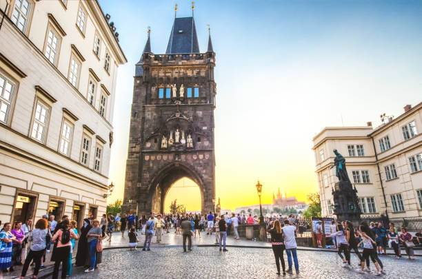 26 may 2018: People are visiting Charles bridge and passing through old town bridge tower in Prague, Czech Republic at sunset