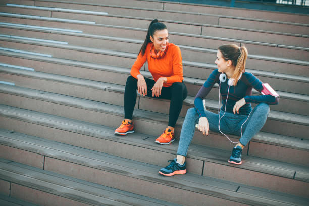 istock Two young woman resting after running 979027968